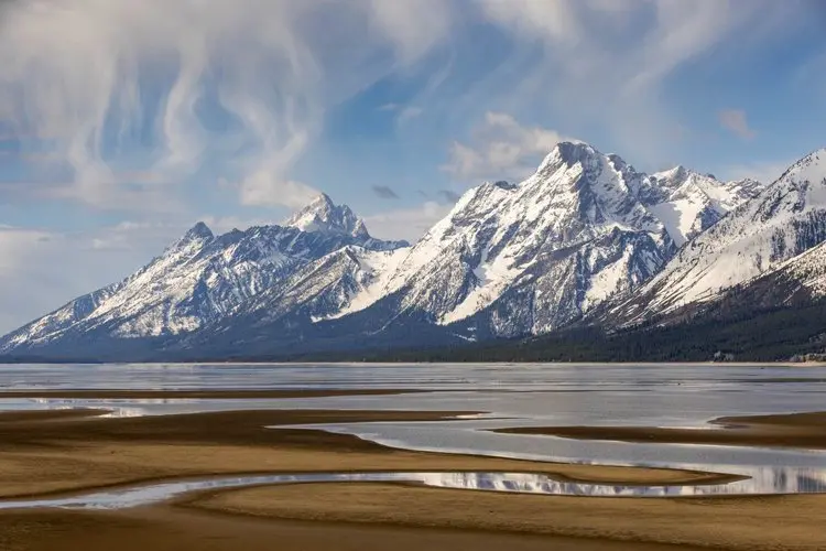 Snowcapped Mountain Range with River Bottom in Foreground
